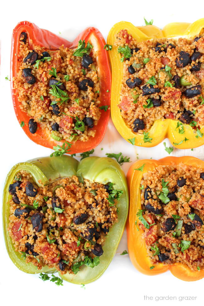 Cooked vegan couscous stuffed bell peppers in a glass pan
