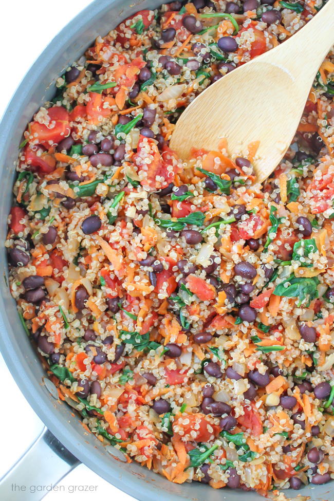 Preparation of stuffed pepper mixture cooking in a skillet with wooden spoon