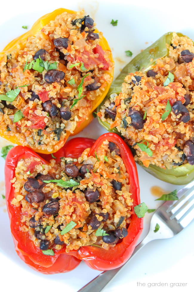 Plate of vegan quinoa stuffed peppers with black beans and vegetables
