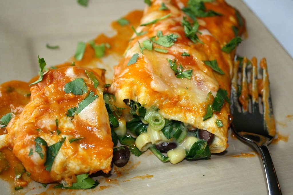 Vegan black bean spinach enchiladas on a plate with fork
