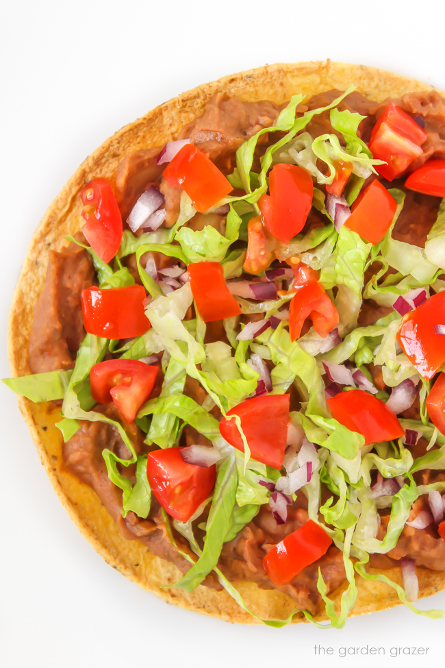 Vegan bean tostada with lettuce, tomato, and onion