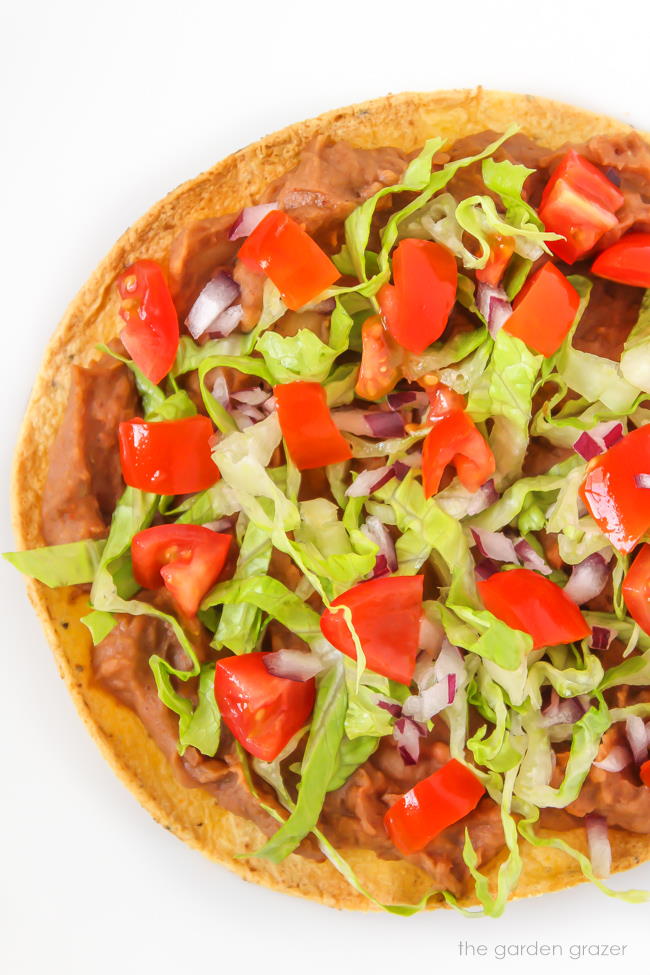 Vegan bean tostada with lettuce, tomato, and onion