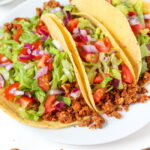 Plate of three vegan tacos with chickpea-walnut taco filling