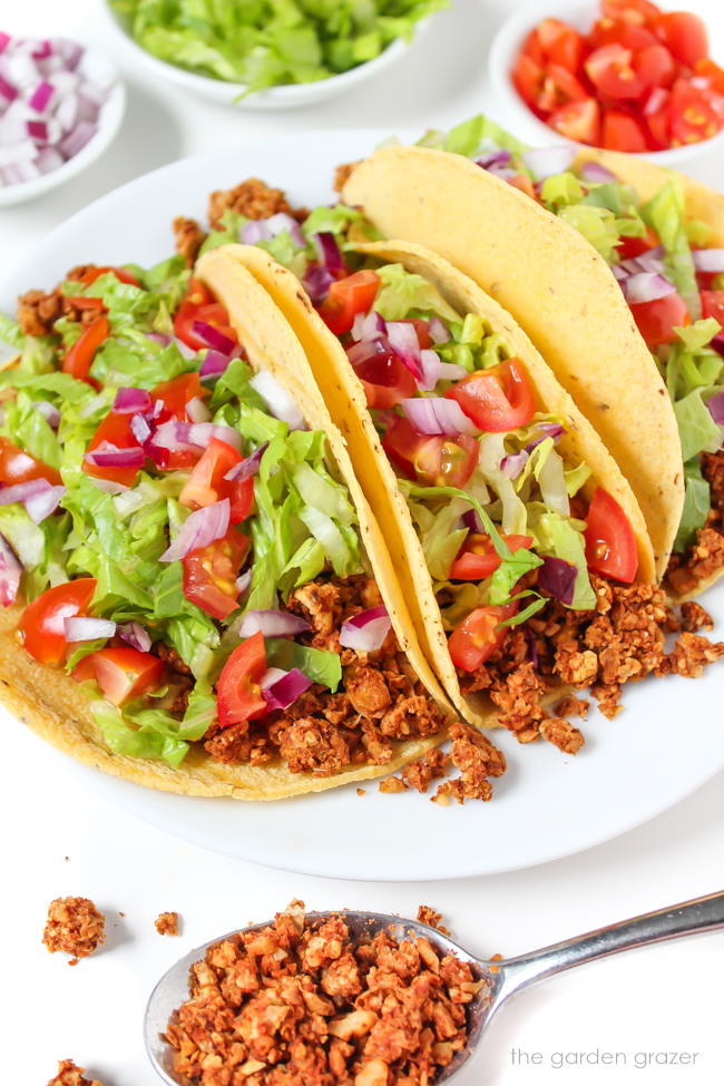 Plate of three vegan tacos with chickpea-walnut taco filling