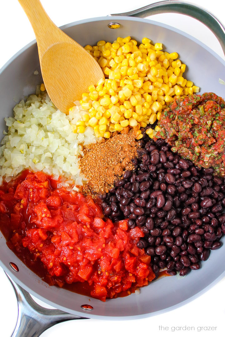 Preparing black beans, tomatoes, salsa, onion, garlic, and sweet corn in a large skillet before stirring together