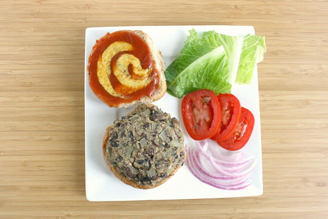 Black bean mushroom burger on a plate with assorted toppings