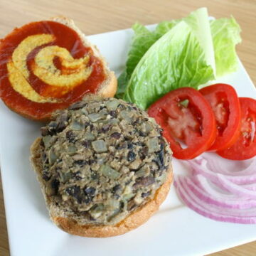 Vegan black bean mushroom burger on a bun with toppings