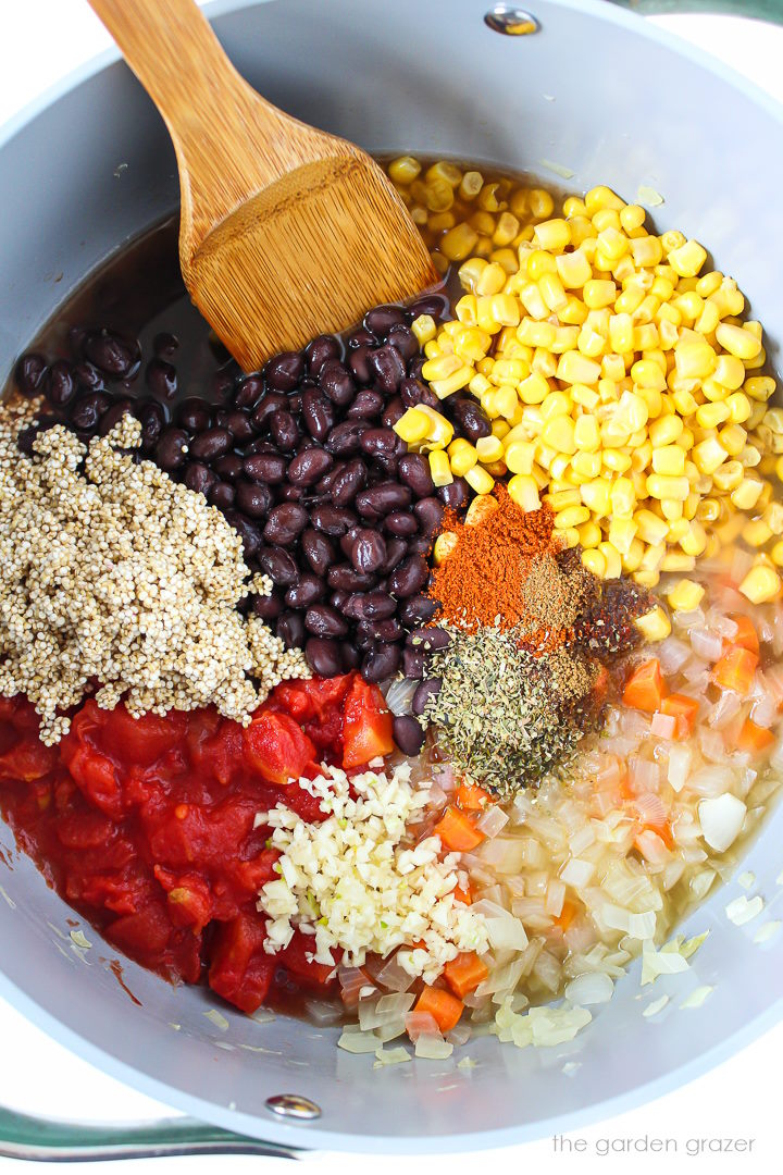 Overhead view of preparing soup ingredients in a large pot before stirring together and cooking