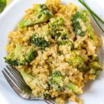 Broccoli quinoa casserole with creamy cashew sauce on a white serving plate with fork