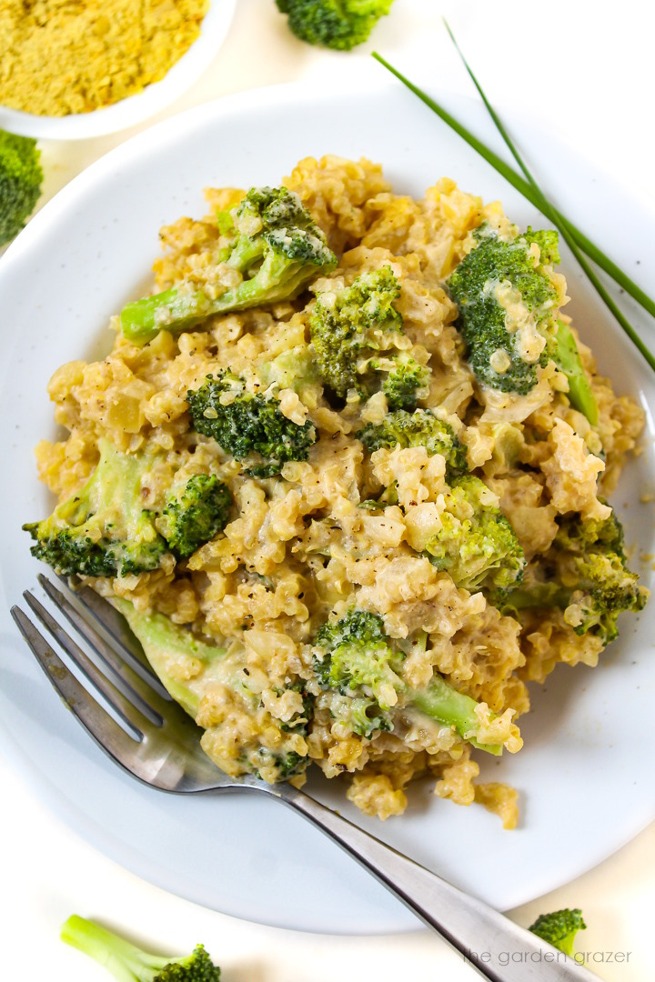 Broccoli quinoa casserole with creamy cashew sauce on a white serving plate with fork
