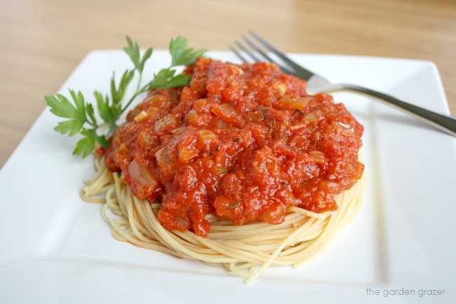 Spaghetti on a white plate with parsley garnish