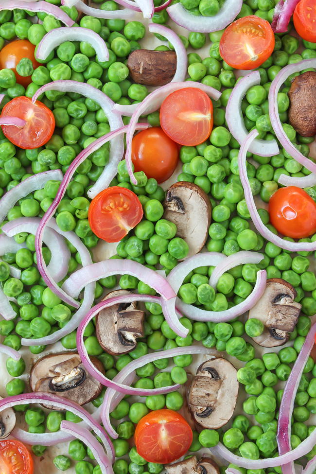 Sheet pan with roasted peas, mushrooms, tomato, and onion