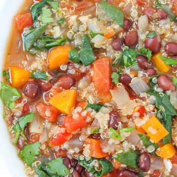 Close up view of vegan black bean and quinoa soup garnished with cilantro