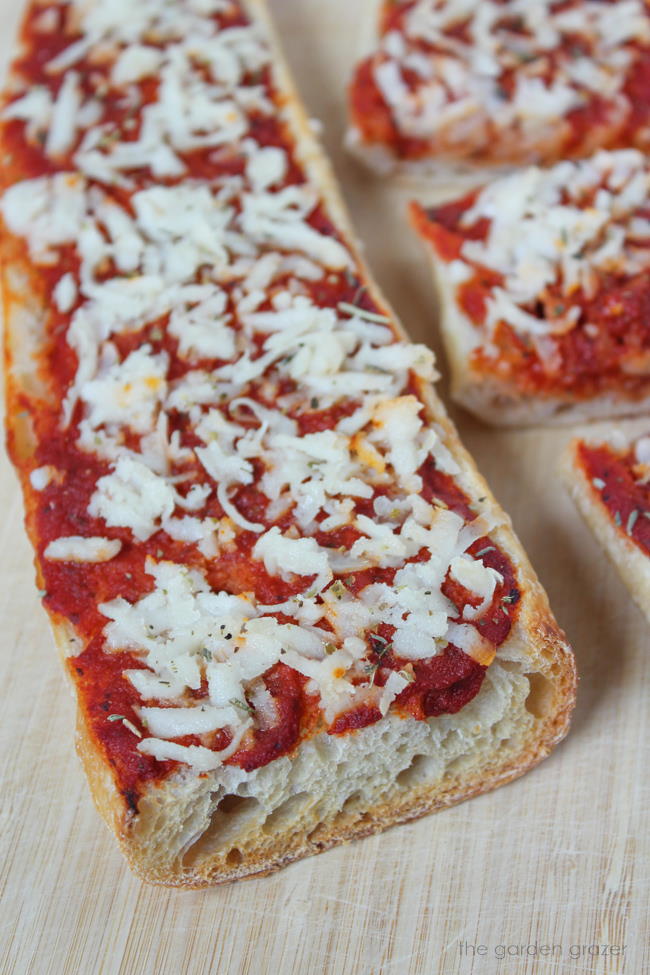 Vegan French bread cheese pizza on a cutting board