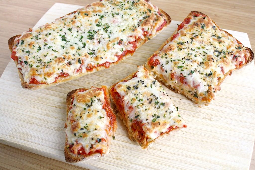 Vegan french bread cheese pizza on a cutting board