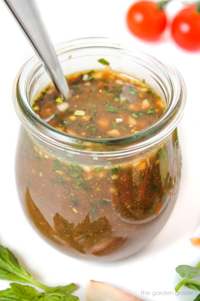 Oil-free basil balsamic dressing in a small jar with spoon