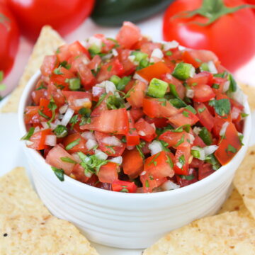 Salsa fresca in a white bowl with tortilla chips on the side