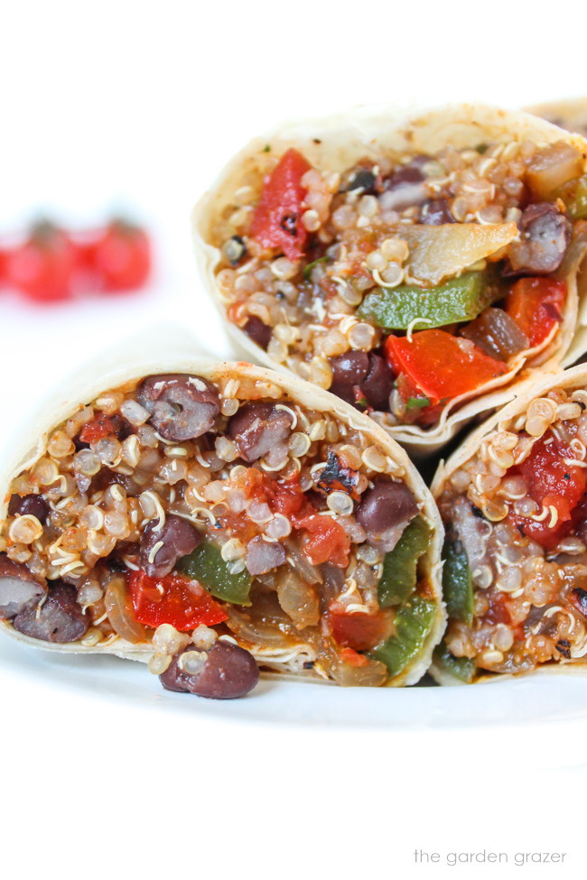 Quinoa burritos cut open on a white plate