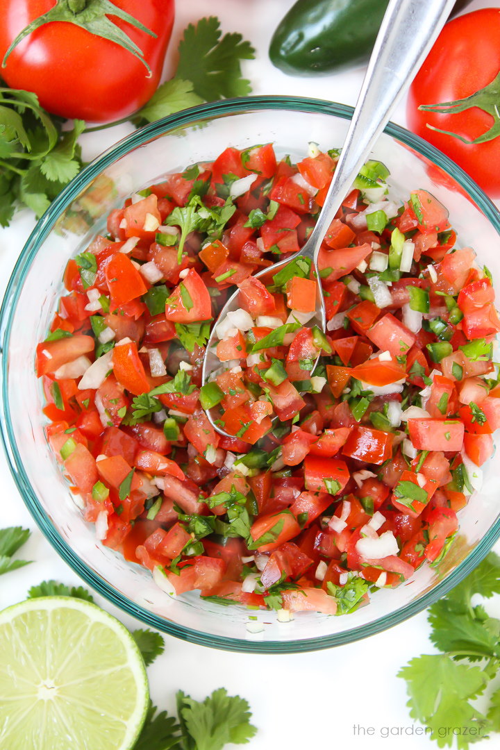 Fresh salsa fresca in a large glass bowl with serving spoon