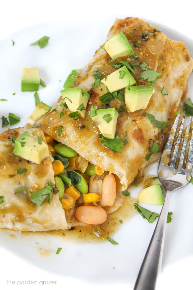 Plate with vegan green enchilada topped with salsa verde