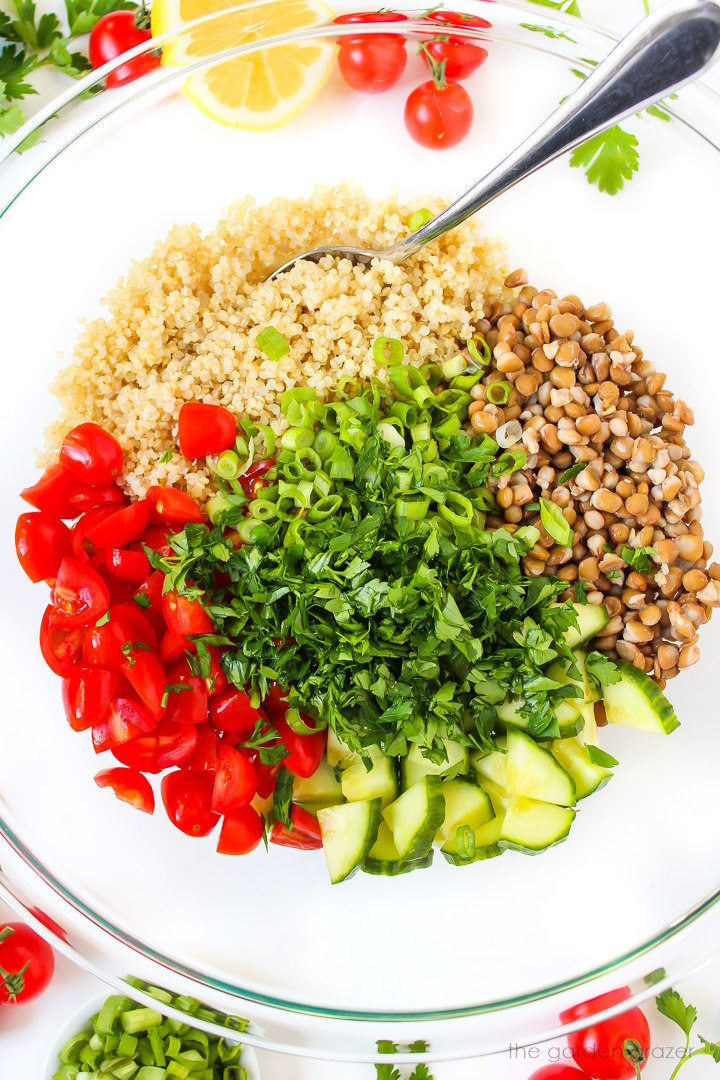 Overhead view of preparing salad ingredients together in a large bowl before mixing together