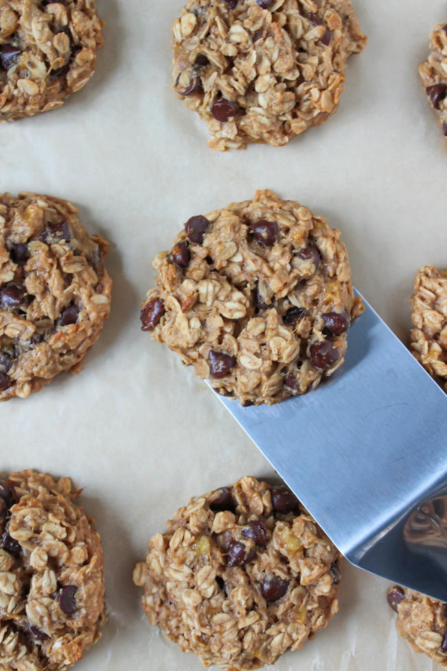 Picking up a banana oat cookie with spatula from a sheet pan