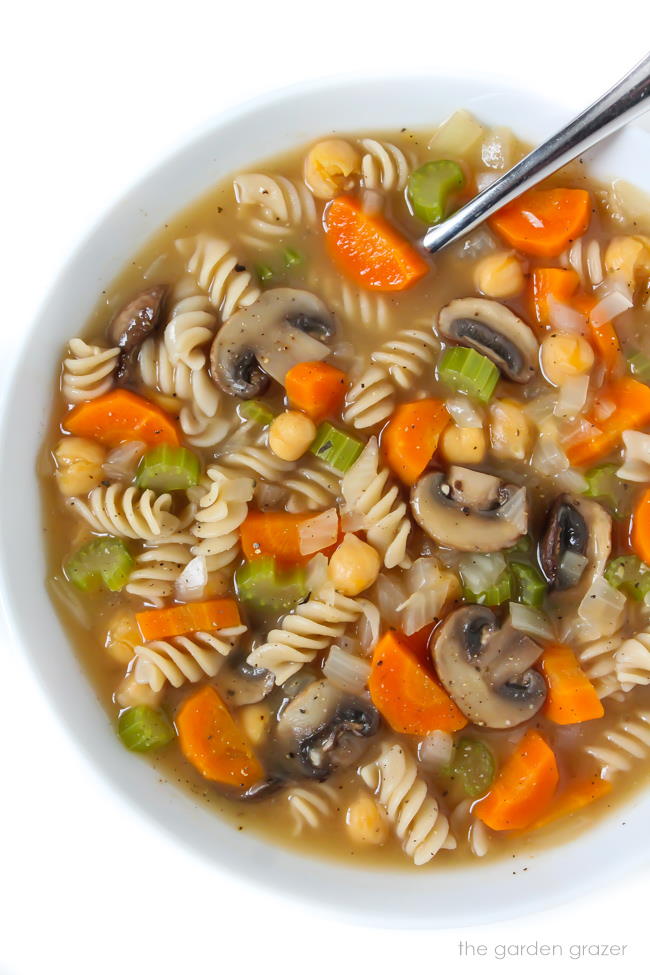 Bowl of noodle soup with chickpeas, mushrooms, and carrots