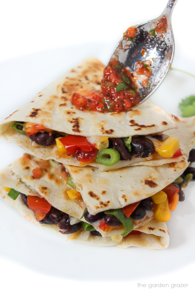 Cut vegan black bean and corn quesadillas stacked on a white plate