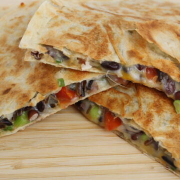 black bean quesadilla with tomato on a cutting board