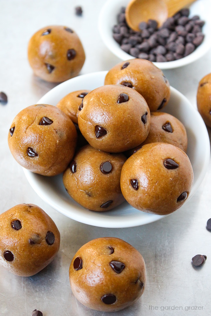 Vegan cookie dough bites with chocolate chips piled together in a small white bowl