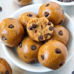 Small bowl of chocolate chip cookie dough bites with a bite taken out of one