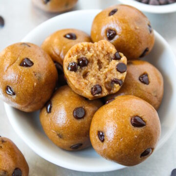 Small bowl of chocolate chip cookie dough bites with a bite taken out of one