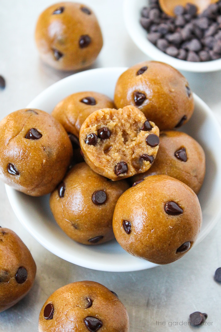 Small bowl of chocolate chip cookie dough bites with a bite taken out of one