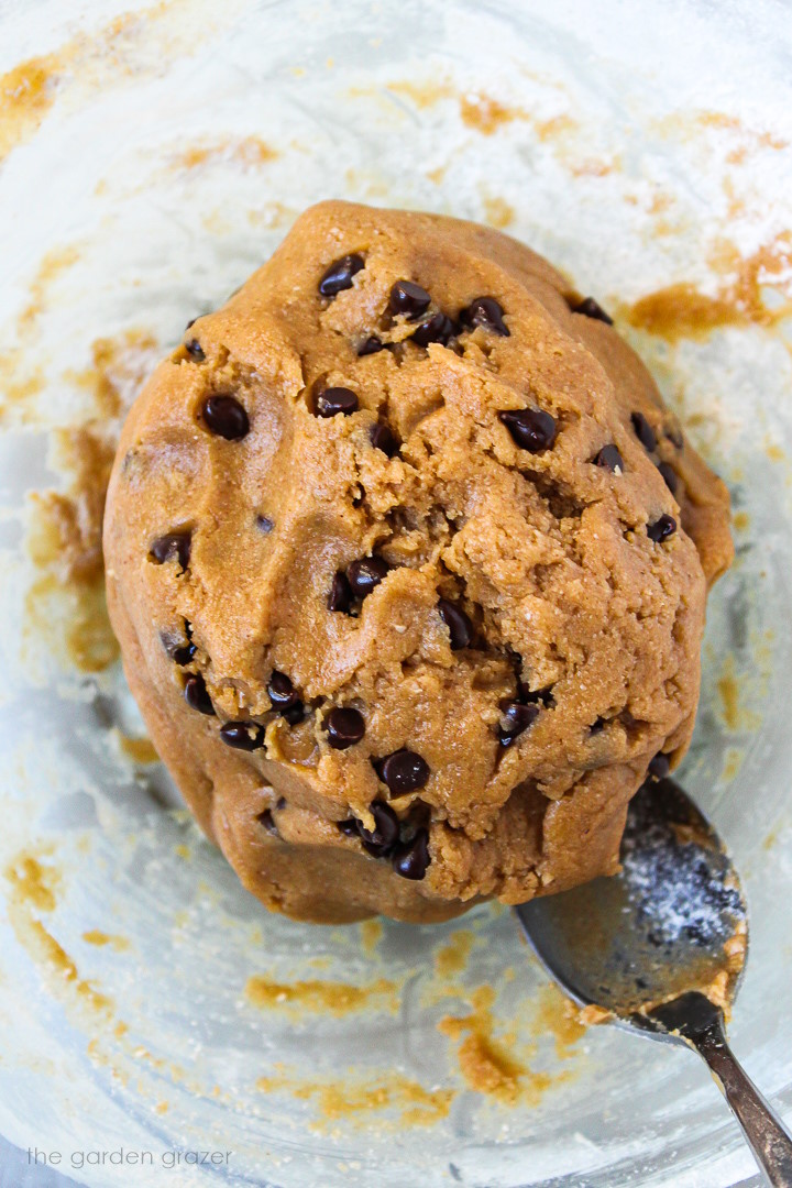 Overhead view of vegan cookie dough bites batter mixed together with mini chocolate chips in a large bowl