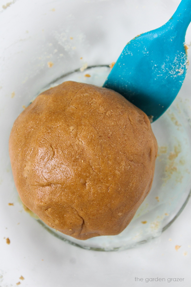 Preparing cookie dough batter in a large glass bowl with spatula