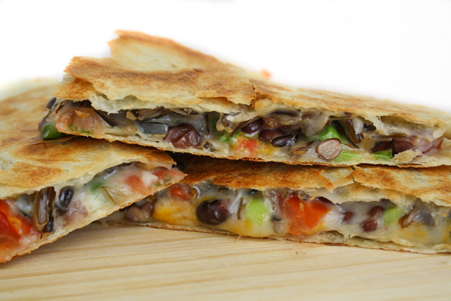 black bean quesadillas cut in half on cutting board