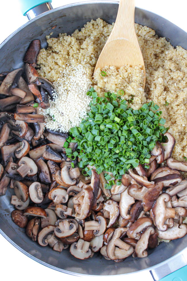 Ingredients in a pan for toasted quinoa and mushrooms before stirring together