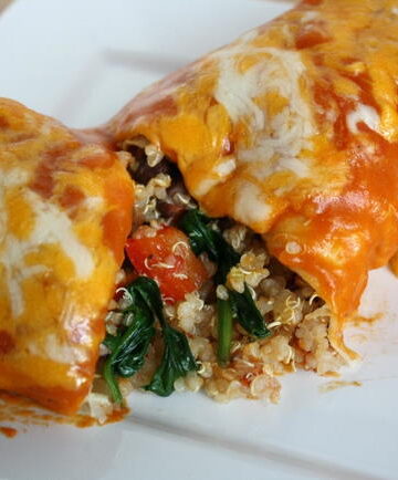 Vegan vegetable quinoa enchilada cut open on a white plate