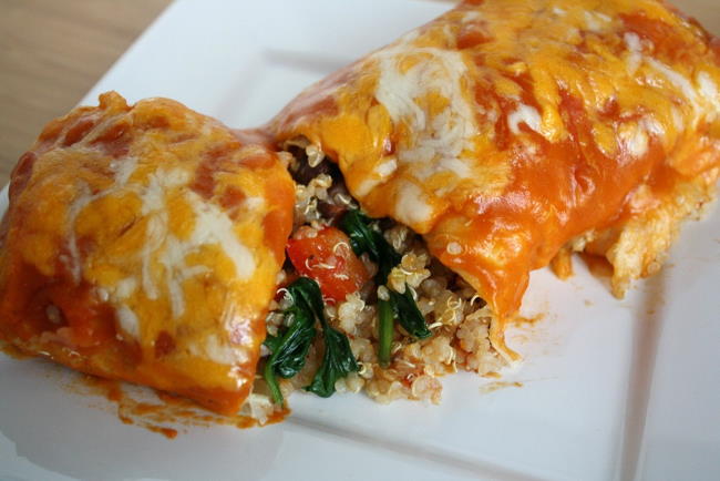Vegan vegetable quinoa enchilada cut open on a white plate