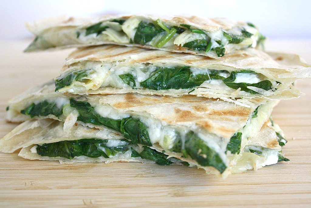 Cutting board with four spinach quesadillas