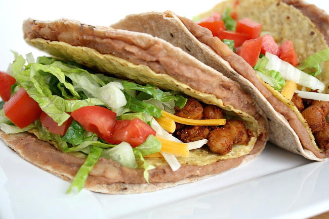 Vegan double decker chickpea tacos on a plate with lettuce and tomato