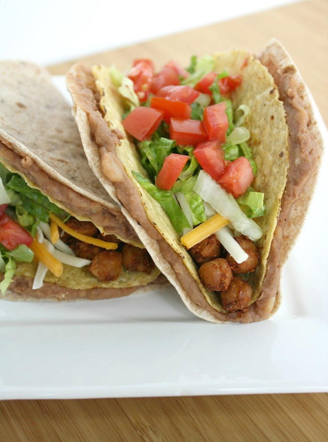 Two double decker chickpea tacos on a white plate