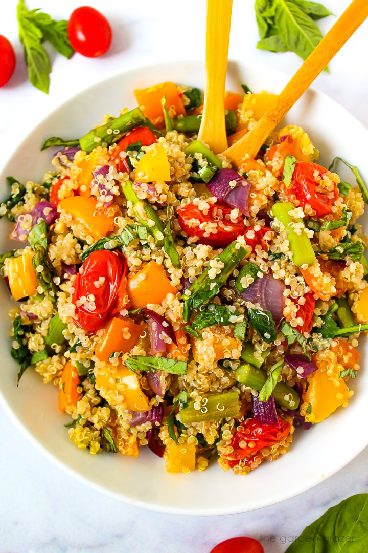 Overhead view of quinoa with roasted vegetables in a white serving bowl