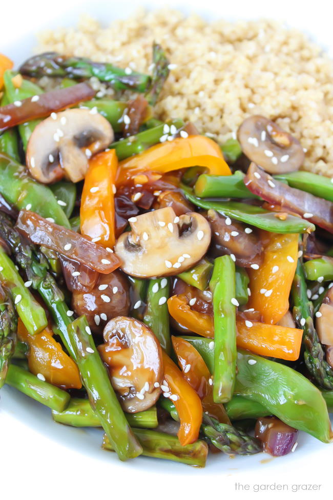 Quinoa stir fry with vegetables in a white bowl