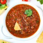 Restaurant style blender salsa served in a white bowl with chips and fresh cilantro