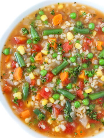 Bowl of vegan vegetable barley soup topped with parsley