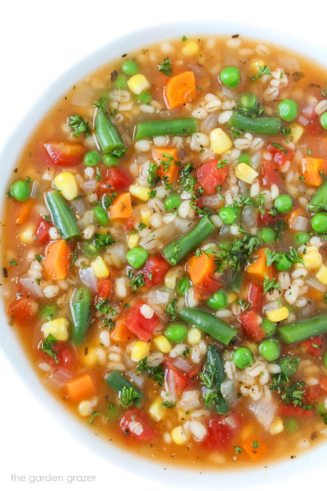 Bowl of vegan vegetable barley soup topped with parsley