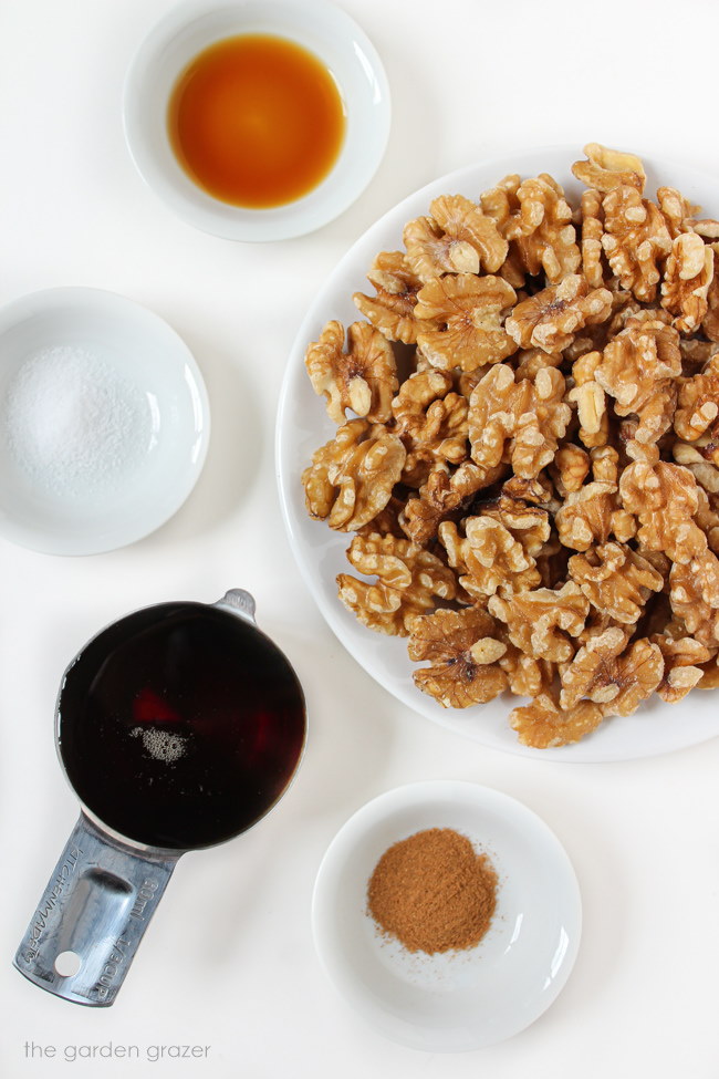 Walnuts, maple syrup, vanilla, and other ingredients on a white table