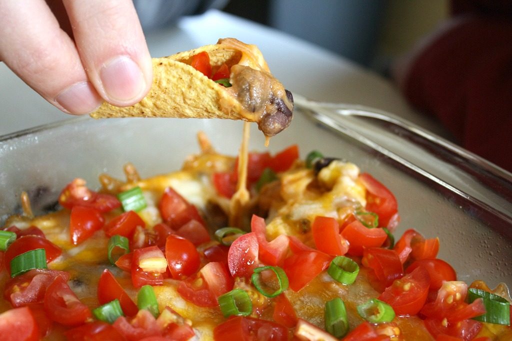 Tortilla chip dipping into vegan bean dip