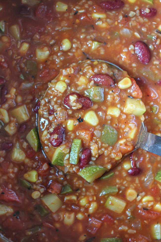 Cooking and preparing chili in a large stockpot with ladle